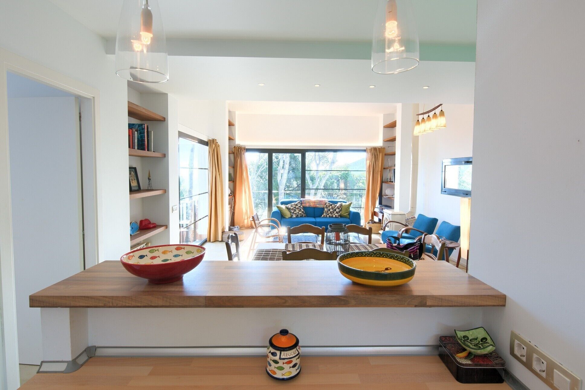 A modern kitchen with a wooden countertop, two large bowls, and a small decorative item.