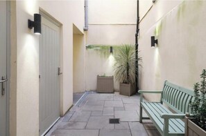 A narrow alleyway with a bench, a potted plant, and a door. - Stylish One-Bed Apartment in Central Bath Near Train Station & Top Attractions (Bath)