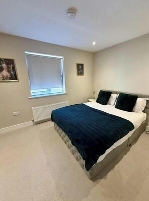 A bedroom with a bed, a window, a radiator, and a picture on the wall. - Stylish One-Bed Apartment in Central Bath Near Train Station & Top Attractions (Bath)