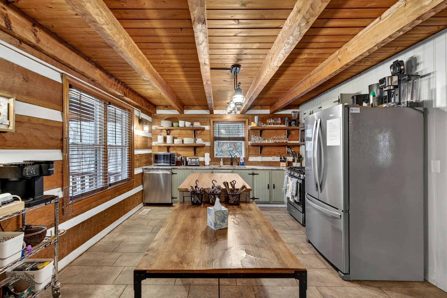 Una cocina moderna con vigas de madera, electrodomésticos de acero inoxidable y una isla central.