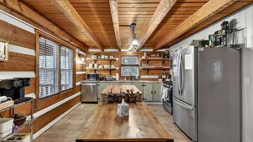 Una cocina moderna con vigas de madera, electrodomésticos de acero inoxidable y una isla central.