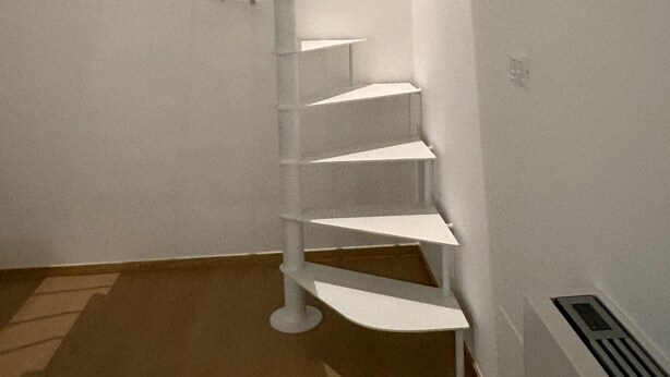 A spiral staircase in a room with white walls and a wooden floor. - "Between Sky and Sea" Apartment in Pescara. Sea: 200 m. University 700 m.  Parking (Pescara)