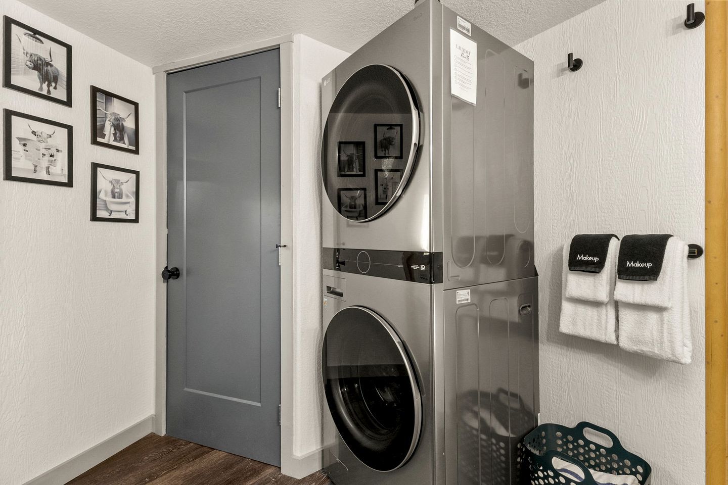 A laundry room with two washing machines, a door, and a wall-mounted towel rack with towels.