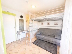 A compact room with a bunk bed, a small desk, and a sofa. - Cozy studio, pets and parking - 3 guests (Sète)