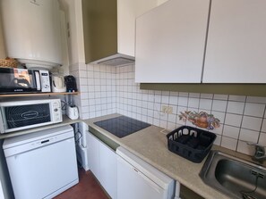 A compact kitchen with a microwave, toaster, and Bosch dishwasher. - Apartment with AC, sea view - 3 guests (Collioure)