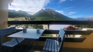 A balcony with a table and chairs, overlooking a mountainous landscape with a clear sky. - Sunny studio with south balcony - 2 guests (Montgenèvre)