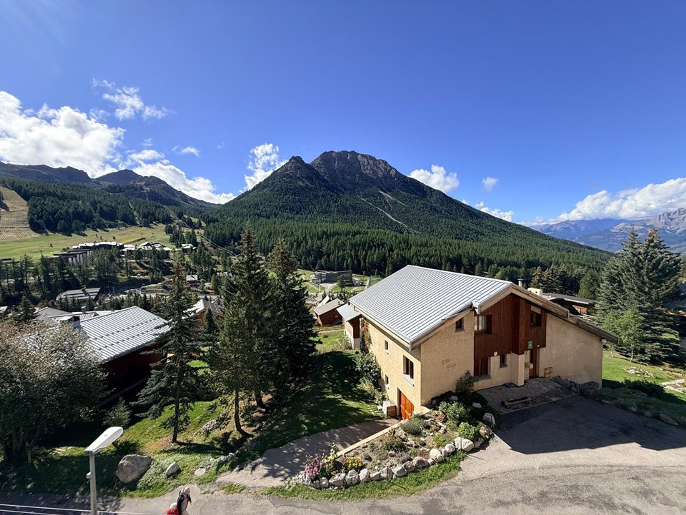 Een bergdorp met traditionele gebouwen, een heldere lucht en een opvallende berg op de achtergrond.
