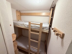 A bunk bed room with a wooden ladder and a small shelf. - Studio with wifi - Piste view, 2 guests (Montgenèvre)