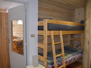 A compact room with a bunk bed, a desk, and a mirror. - Studio with pets allowed, parking - 4 guests (Montgenèvre)