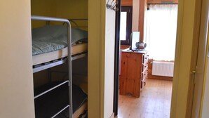A dormitory room with bunk beds, a wooden dresser, and a window with curtains. - Studio with pets allowed in Montgenèvre (Montgenèvre)
