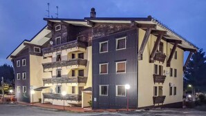 A multi-story building with balconies, a gated entrance, and a satellite dish. - Dolce Casa - Residence La Montanara (Camigliatello Silano)