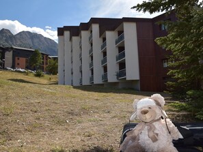 A modern building with multiple balconies and a grassy area in front. - Studio at the foot of the slopes - 4 guests (Montgenèvre)