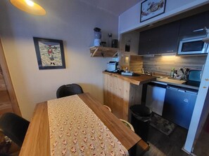A compact kitchen with a wooden countertop, a built-in microwave, and a small sink. - Studio at the foot of the slopes - 4 guests (Montgenèvre)