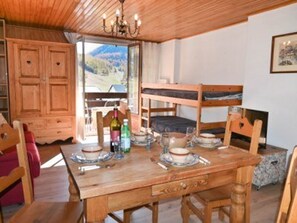 Ein gemütliches Zimmer mit Holzmöbeln, einem Etagenbett und Bergblick.