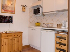 A compact kitchen with white cabinets, a microwave, a yellow pot, and a coffee maker. - Studio in Montgenèvre center - 3 guests (Montgenèvre)