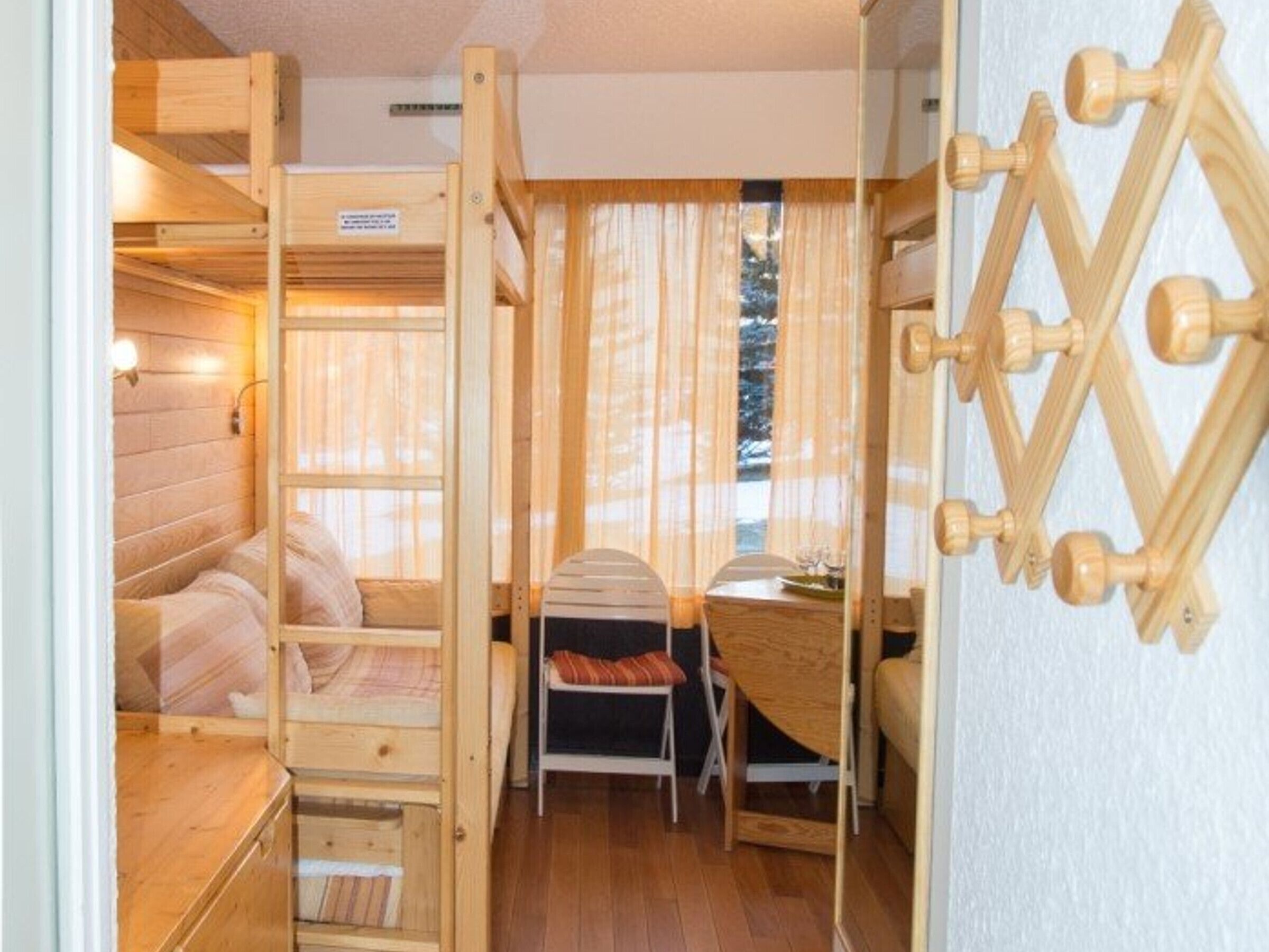 Una habitación acogedora con una cama litera, un escritorio y una silla.