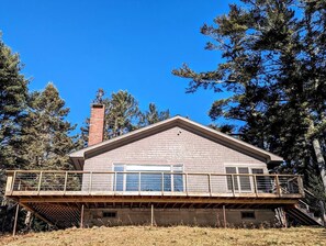 A two-story house with a balcony, a chimney, and a clear blue sky. - Secluded Oceanfront Cottage with Wrap-Around Deck near Acadia National Park, Sullivan, Maine (Sullivan)