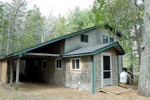 A two-story cabin with a covered porch and a small deck. - Charming Waterfront Cottage with Scenic Views, Kayak Access, Near Bar Harbor, Mount Desert Island, Maine (Mount Desert)