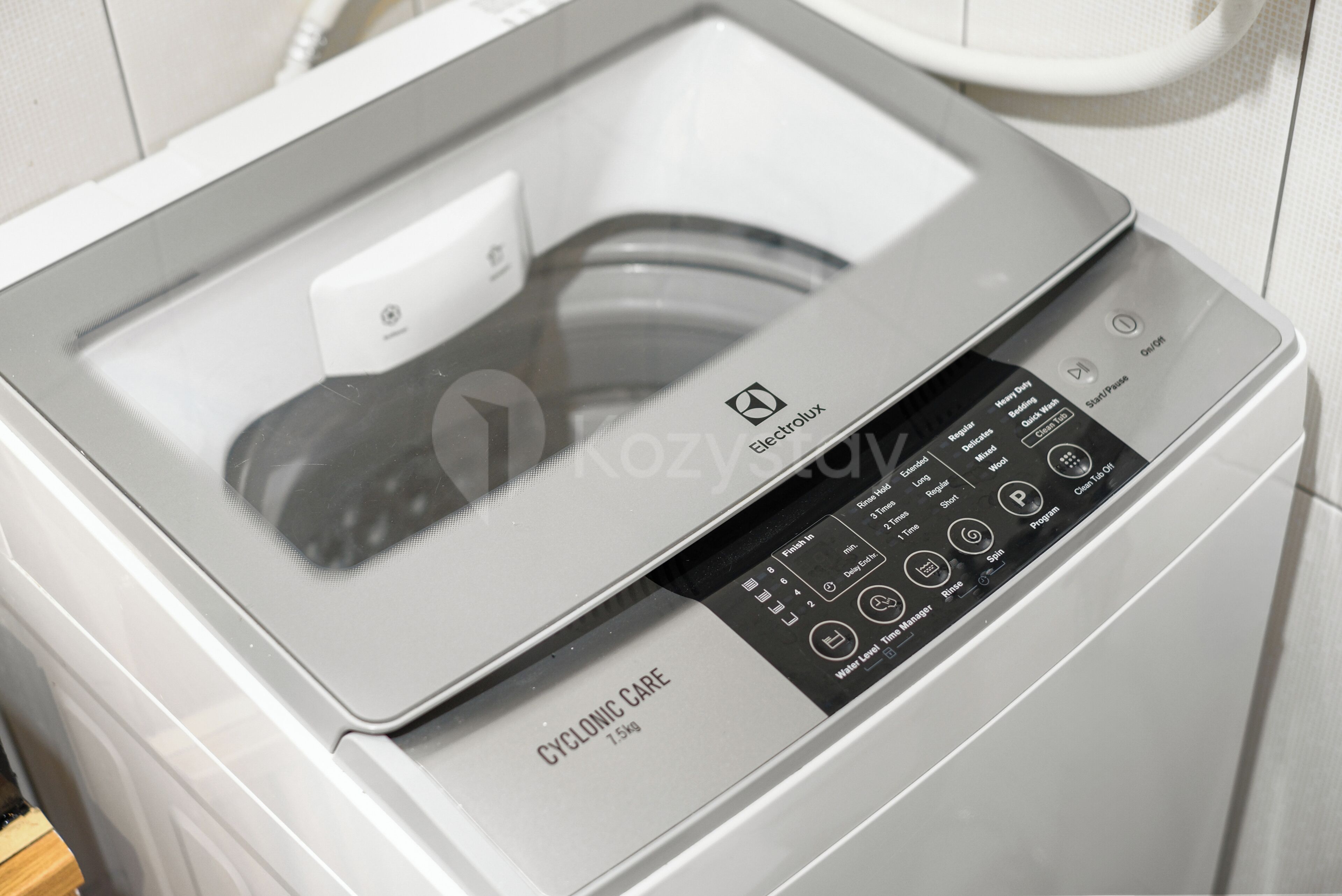 A front view of a white washing machine with a control panel and a glass door.