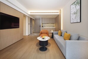 Una sala de estar moderna con sofá, mesa de centro y televisor de pantalla plana.