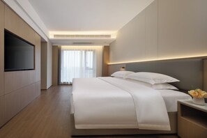 A modern hotel room with a large bed, a flat-screen TV, and a view of the outdoors. - Poltton International Apartment (Guangzhou Design Capital, Jiahewanggang Metro Station) (Guangzhou)