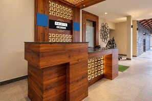 Un comptoir d’accueil avec un revêtement en bois et un motif géométrique sur le mur du fond.