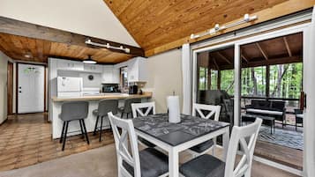 A modern kitchen with white cabinets, a central island, and bar stools.