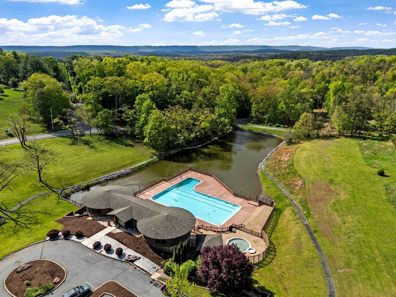 Una piscina con vistas a un río y zona boscosa.