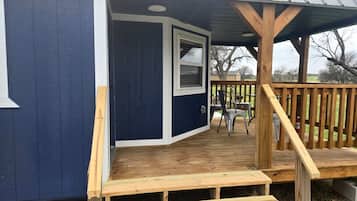 A small building with a wooden deck, a window, and a door.