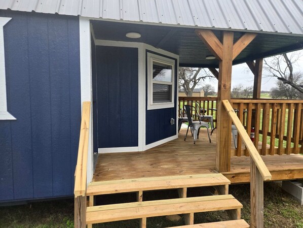 A small building with a wooden deck, a window, and a door.