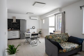 A modern apartment with a kitchen, dining area, and living room. - Aroma Holiday House with Wi-Fi and Air Conditioning (Rome)