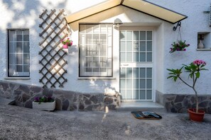 A house with a stone foundation, a wooden lattice, and a small potted plant. - Aroma Holiday House with Wi-Fi and Air Conditioning (Rome)