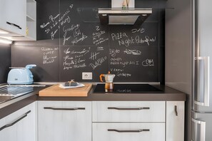 A modern kitchen with a blackboard, a kettle, a coffee pot, and a stainless steel refrigerator. - Holiday Home 'Aroma Holiday House' with Wi-Fi and Air Conditioning (Rome)