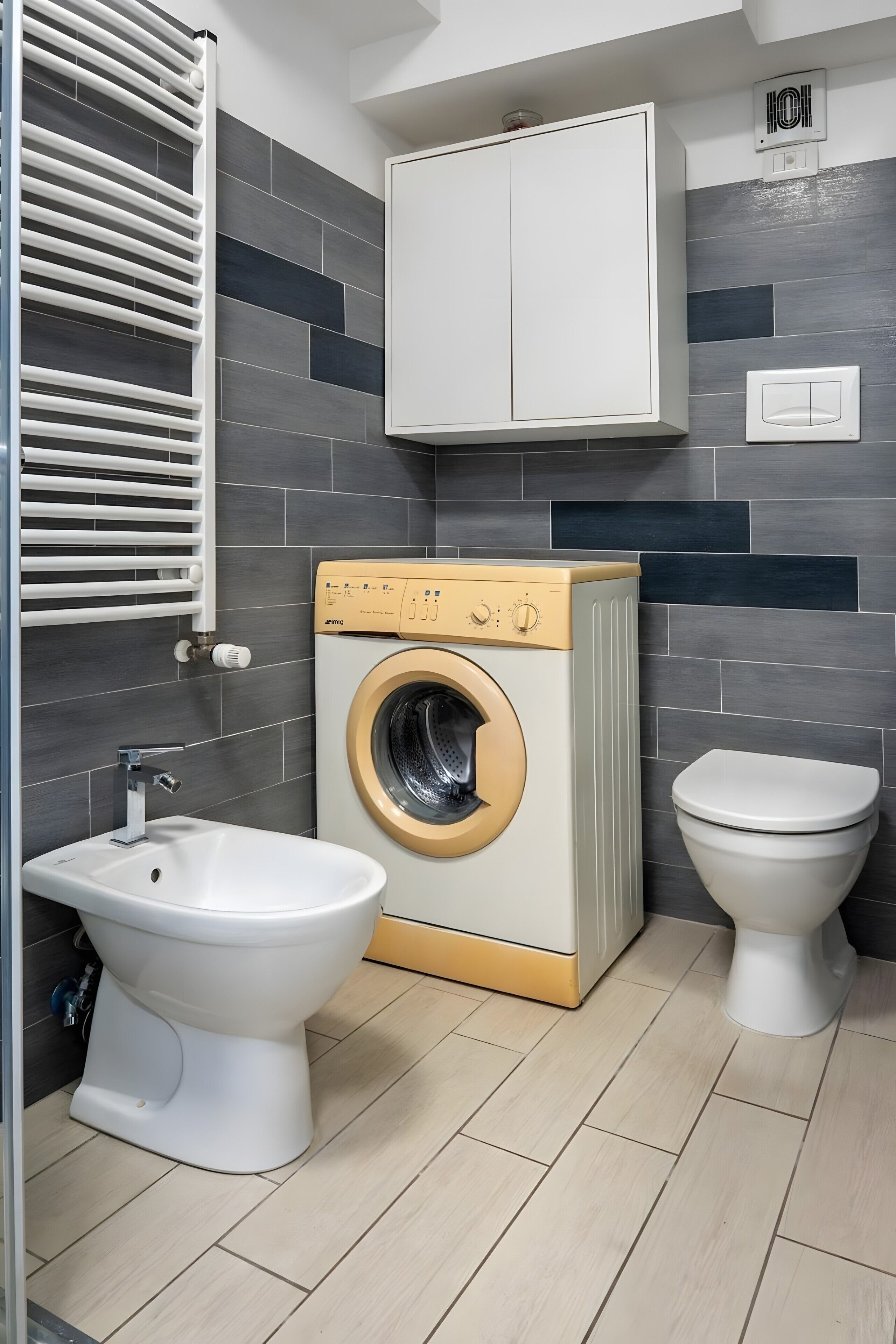 Un bany compacte amb rentadora, dues vàteres, un bidet i un suport per a tovalloles.