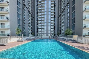 A high-rise residential building with a central swimming pool, multiple balconies, and a modern architectural design. - Your Urban Haven in Sobha Hartland (Dubai)