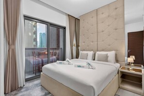 A hotel room with a large bed, a sliding glass door leading to a balcony, and a modern headboard. - Your Urban Haven in Sobha Hartland (Dubai)