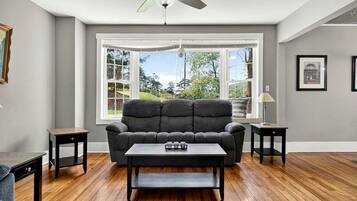 A living room with a sofa, coffee table, and a ceiling fan.