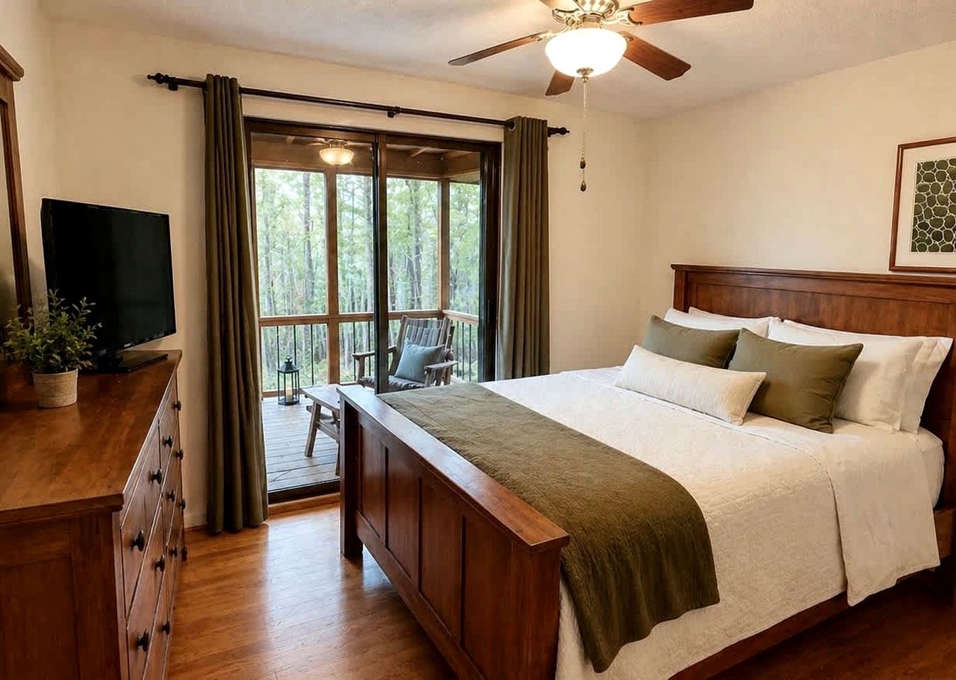 A bedroom with a bed, a television, a desk, and a window with curtains.