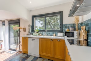 A modern kitchen with a dishwasher, a window, a microwave, and a sink.