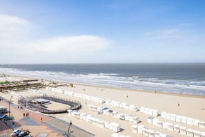 Ein Strand mit weißen Strandhütten, einem Sandbereich und Blick auf den Ozean.