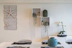 A room with a white wall, a wooden starfish decoration, a shelf with plants, and a vase. - 3 bedroom accommodation in Blankenberge (Blankenberge)