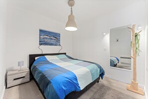 A bedroom with a bed, bedside table, lamp, wall art, and a mirror. - 3 bedroom accommodation in Blankenberge (Blankenberge)