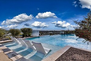Una piscina con toboganes, cielo despejado y una vista distante del paisaje.