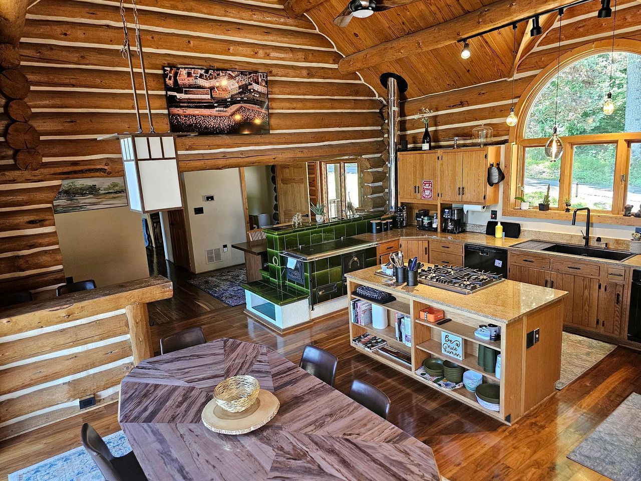 A spacious kitchen with wooden cabinetry, a central island, and a dining area with a large table.