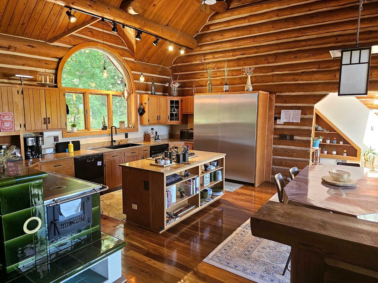 A spacious kitchen with wooden beams, a large island, and a built-in oven.