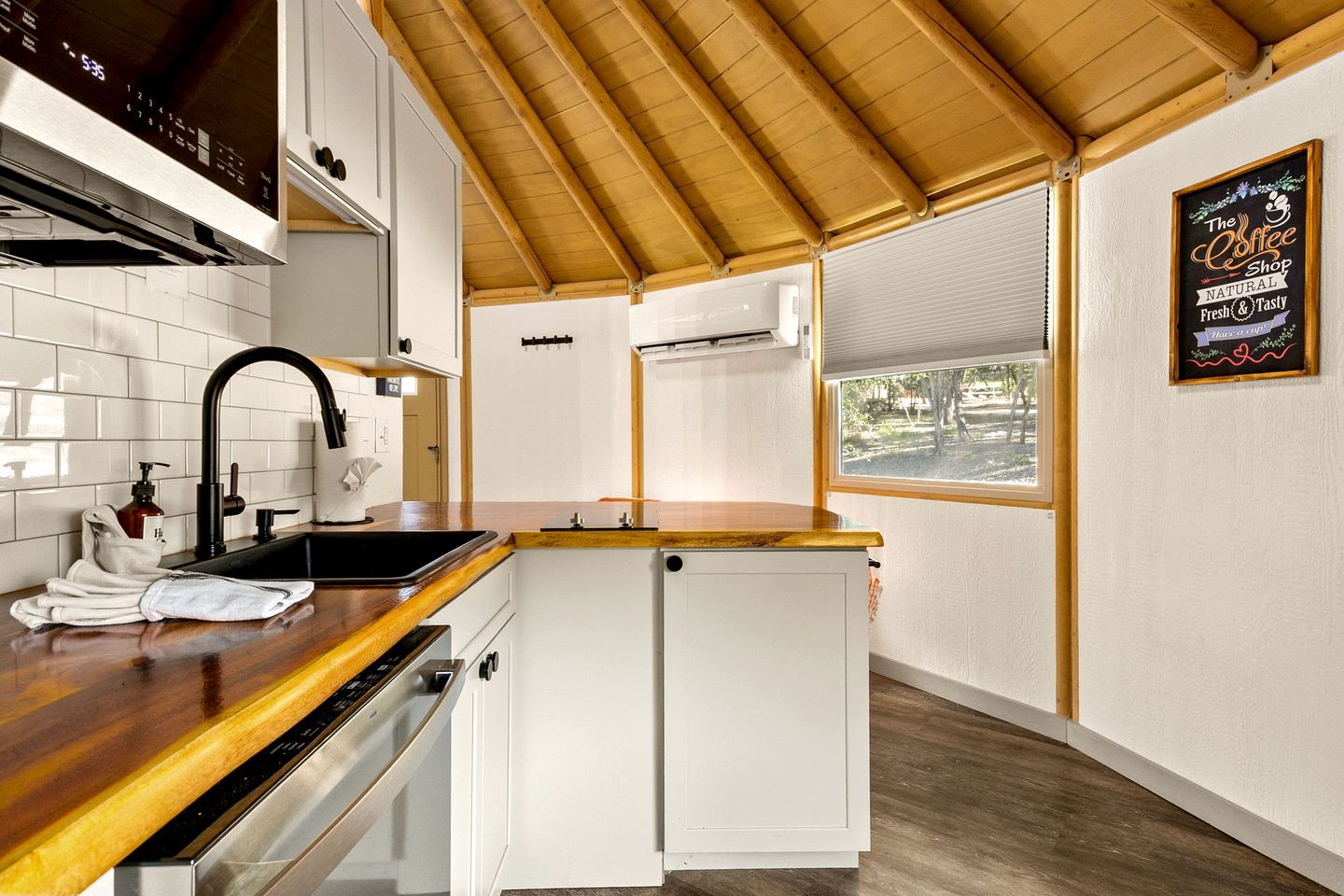 A compact kitchen with a wooden countertop, a sink, and a small refrigerator.