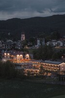 Uma cidade com uma torre de igreja imponente, um hotel moderno com vários andares e edifícios residenciais ao redor.