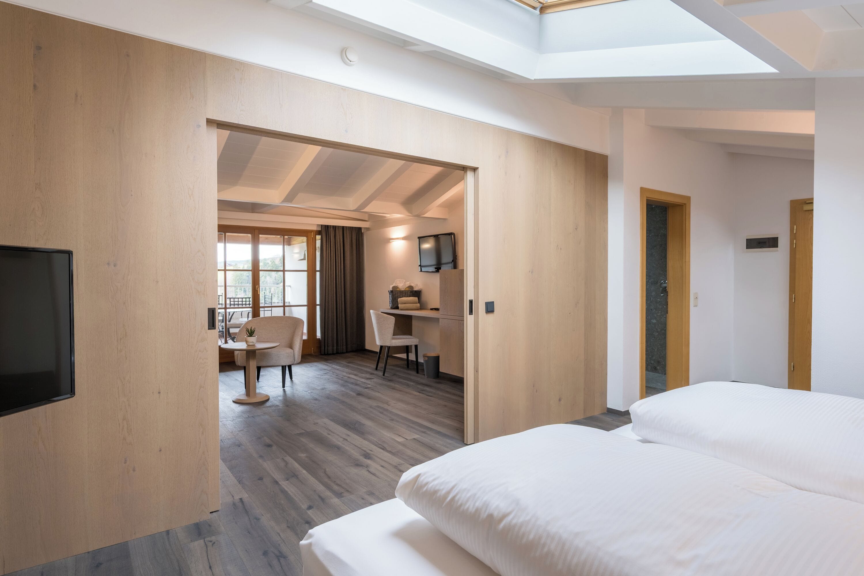 Una habitación de hotel con cama, escritorio, silla y televisor.