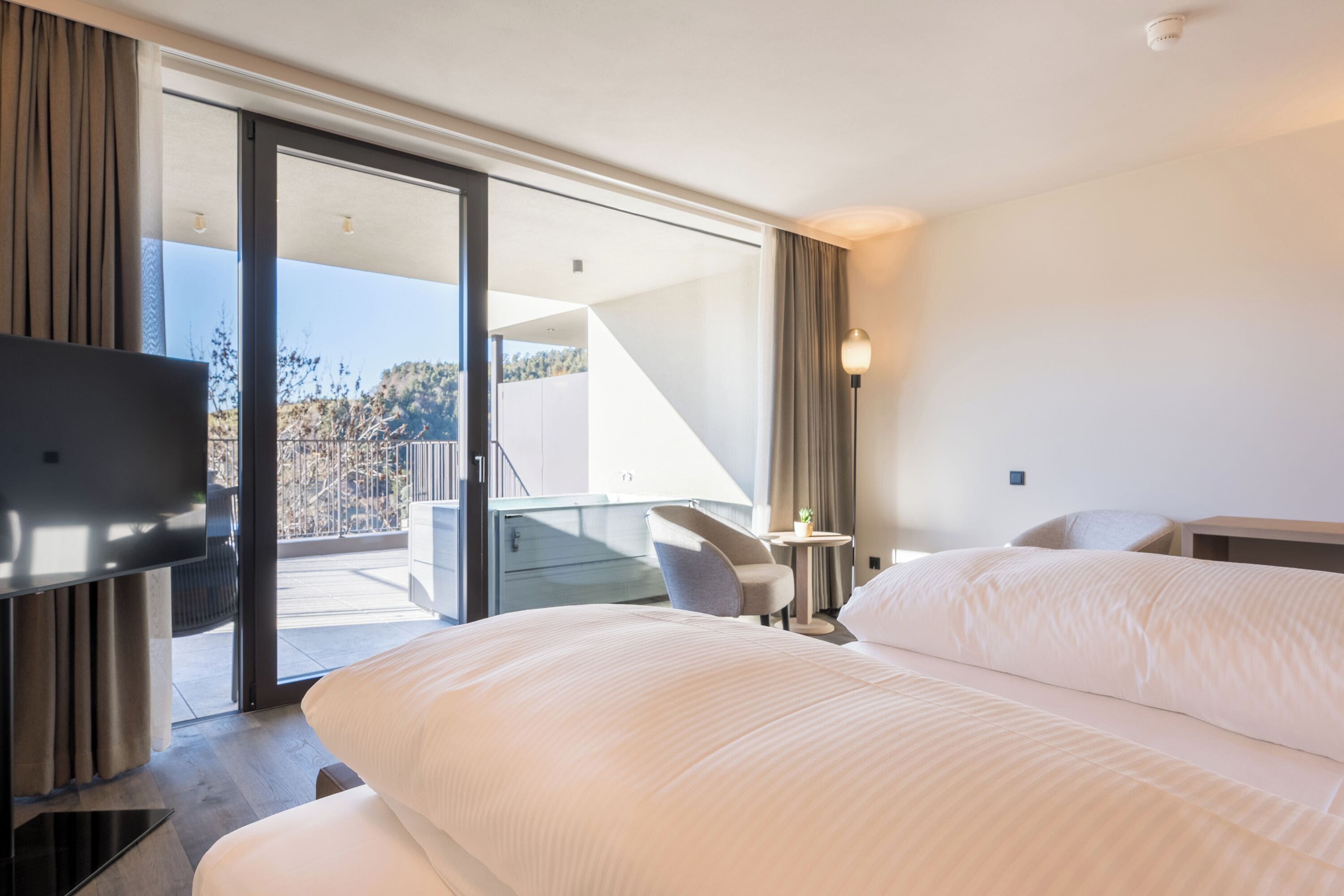 Una habitación de hotel con cama, televisión, escritorio y una silla.