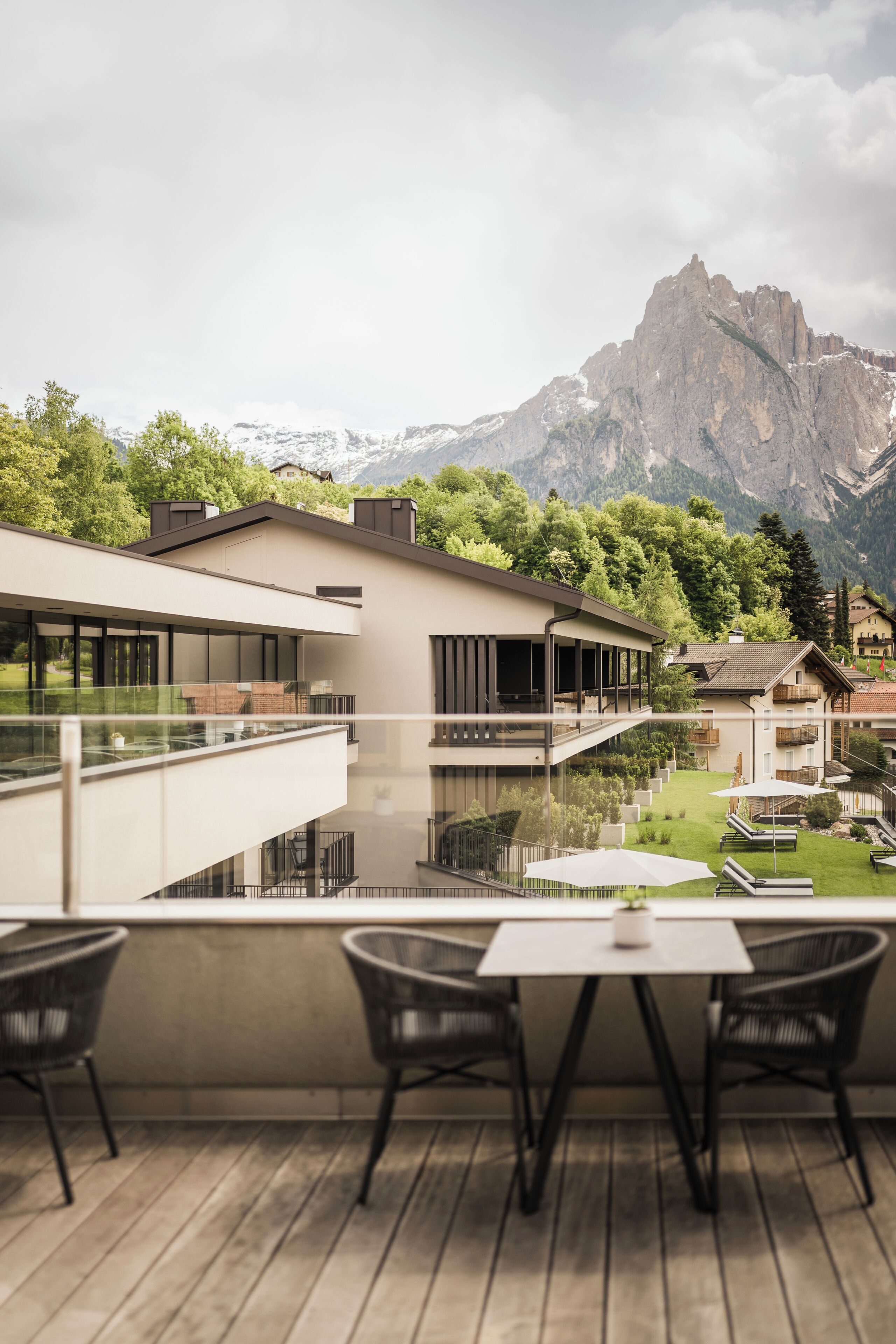 Un edificio moderno con un balcón que da a un paisaje montañoso.